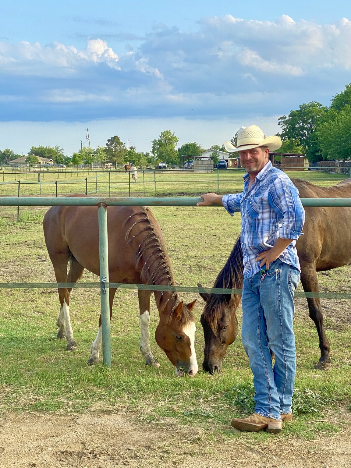 Trevor Snowden standing beside two horses in a Central Texas pasture